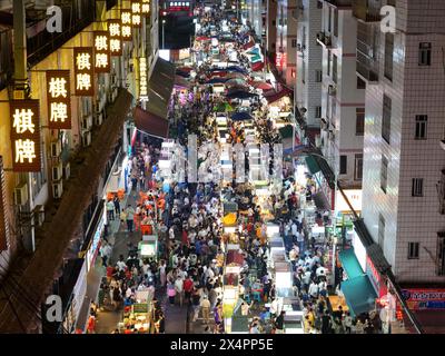 NANNING, CINA - 4 MAGGIO 2024 - foto aerea scattata il 4 maggio 2024 mostra i turisti che si riuniscono davanti alle bancarelle in un mercato notturno a Nanning, Cina meridionale Foto Stock