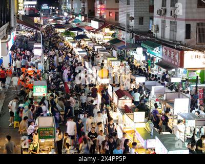 NANNING, CINA - 4 MAGGIO 2024 - foto aerea scattata il 4 maggio 2024 mostra i turisti che si riuniscono davanti alle bancarelle in un mercato notturno a Nanning, Cina meridionale Foto Stock