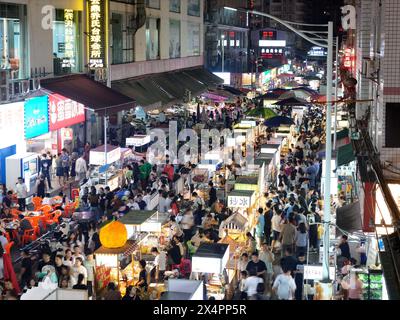 NANNING, CINA - 4 MAGGIO 2024 - foto aerea scattata il 4 maggio 2024 mostra i turisti che si riuniscono davanti alle bancarelle in un mercato notturno a Nanning, Cina meridionale Foto Stock