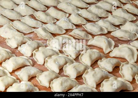 Gnocchi Vareniky prima di essere bolliti. Cibo tradizionale ucraino fatto a mano. Foto Stock