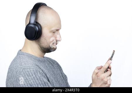 Questo è un ritratto accattivante di un uomo, su uno sfondo bianco. È rivestito di un maglione di lana grigia finemente lavorato a maglia Foto Stock