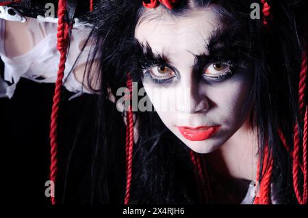 ritratto di donna con trucco sciamano voodoo isolato sul nero Foto Stock