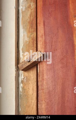 cerniera con bullone a torre nera non installata in modo professionale e serratura su porta in legno, installazione interna non standard in primo piano con spazio di copia Foto Stock