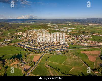 Vista aerea della città di Santpedor e dei verdi campi di Pla de Bages al tramonto primaverile (Barcellona, ​​Catalonia, Spagna) Foto Stock