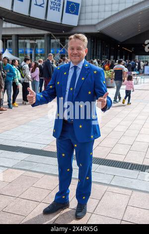 Candidato alle elezioni europee Jacob Stryhn dalla Danimarca con la sua tuta europea durante un giorno aperto per celebrare il compleanno del Parlamento europeo a Bruxelles. Per celebrare il compleanno del Parlamento europeo a Bruxelles, i visitatori hanno avuto accesso speciale alle camere del Parlamento e all'edificio iconico. La giornata aperta ha caratterizzato stand informativi sulle imminenti elezioni del Parlamento europeo, promuovendo l'impegno politico e il dialogo. Sullo sfondo della democrazia europea, i partecipanti si sono immersi nel processo legislativo, simboleggiando la trasparenza e i partecipati civici Foto Stock