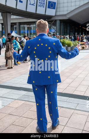 Candidato alle elezioni europee Jacob Stryhn dalla Danimarca con la sua tuta europea durante un giorno aperto per celebrare il compleanno del Parlamento europeo a Bruxelles. Per celebrare il compleanno del Parlamento europeo a Bruxelles, i visitatori hanno avuto accesso speciale alle camere del Parlamento e all'edificio iconico. La giornata aperta ha caratterizzato stand informativi sulle imminenti elezioni del Parlamento europeo, promuovendo l'impegno politico e il dialogo. Sullo sfondo della democrazia europea, i partecipanti si sono immersi nel processo legislativo, simboleggiando la trasparenza e i partecipati civici Foto Stock