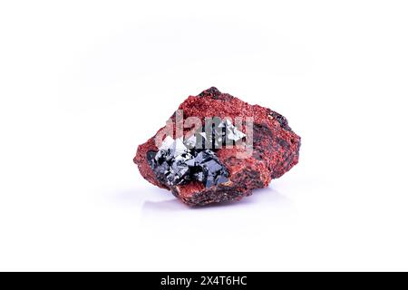 Hausmannite nera su andradite rossa, fotografia isolata su terreno nero bianco. Dalla miniera NChwaning II, Kuruman, Kalahari, Provincia del Capo settentrionale, Sout Foto Stock