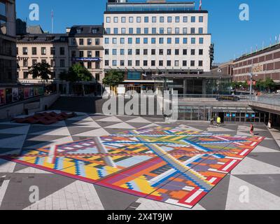 Stoccolma, Svezia - giugno 29 2021: Veduta di piazza Sergels. Edifici sullo sfondo. Grafica a mosaico a colori visualizzata sul quadrato. Persone visibili che camminano lungo Foto Stock