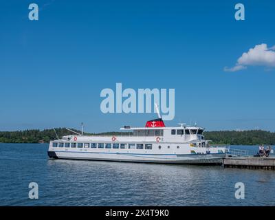 Birka, Svezia - giugno 29 2021: Traghetto passeggeri ormeggiato al molo. Persone che sbarcano dal traghetto. Giorno d'estate con sfondo blu. Foto Stock