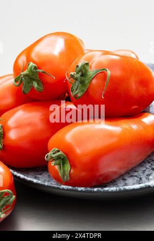 Pomodori lunghi rossi maturi italiani san marzano in tavola Foto Stock