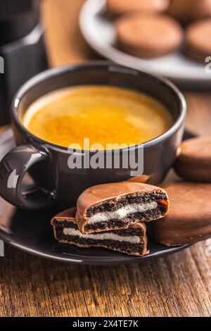 Caffè appena preparato in tazza con biscotti al cioccolato su una piattina Foto Stock