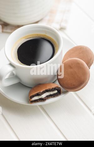 Caffè appena preparato in tazza con biscotti al cioccolato su una piattina Foto Stock