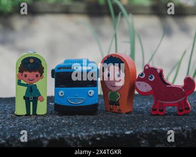 diverse statuette in legno umane e animali su legno e anche un giocattolo in plastica per bambini Foto Stock