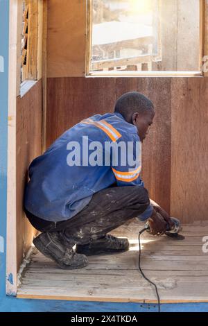 operaio africano che costruisce una casa cubby in legno sul lato della strada , imprenditore di piccole imprese Foto Stock