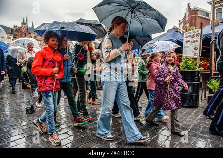 Nijmegen, Paesi Bassi. 4 maggio 2024. I bambini sono visti camminare con i fiori in silenzio durante la cerimonia. In questo giorno, l'intero paese commemora civili e soldati durante la seconda guerra mondiale e altri conflitti. A Nimega, una processione silenziosa ha preso le strade fino al "Keizer Traianusplein", dove si ergono due monumenti in ricordo delle vittime della seconda guerra mondiale. La cerimonia ufficiale è iniziata con due minuti di silenzio, e sono state posate delle corone. Credito: SOPA Images Limited/Alamy Live News Foto Stock