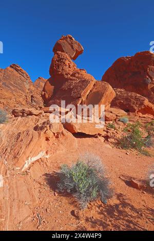 Balancing Rock nella pietra arenaria rossa del Valley of Fire State Park vicino a Overton, Nevada, contro una luminosa verticale blu del cielo Foto Stock