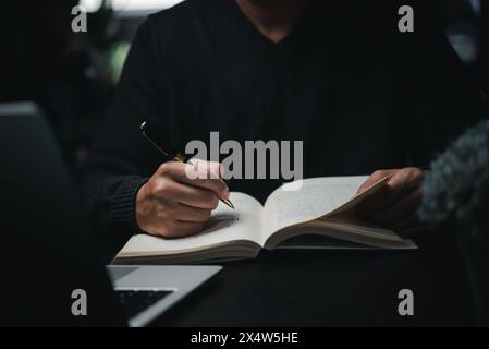 l'uomo mani con la penna scrivere sul notebook in office.learning, l'istruzione e il lavoro.scrive obiettivi, piani, fare a fare e la lista dei desideri sulla scrivania. Foto Stock