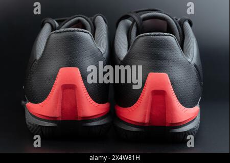 Vista posteriore di un paio di scarpe in pelle nera con suola rossa isolata su sfondo studio Foto Stock