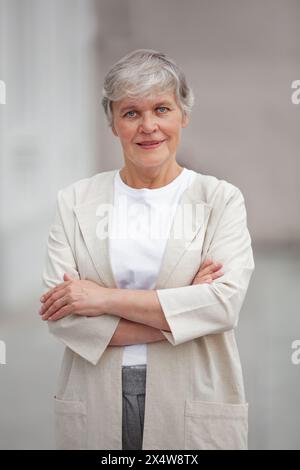 Bella donna professionale senior, felice fiducioso imprenditore modello positivo in piedi all'aperto in strada, donna matura con corte ha grigio Foto Stock