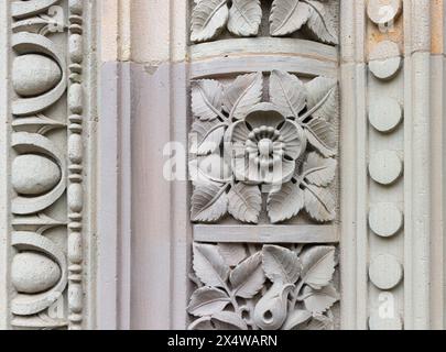 Vecchio muro di pietra, decorato con foglie e fiori. Foto Stock