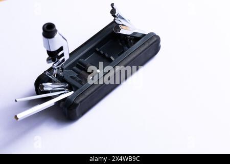 multitool multifunzione per bicicletta nera aperto su sfondo bianco. Utensili in acciaio cromato. Attrezzi per la riparazione automatica di biciclette . Foto Stock