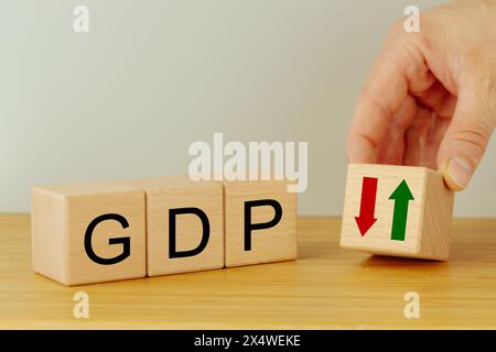 Concetto di prodotto interno lordo. GDP scritto su blocchi di legno, icona con la freccia giù. Politica monetaria, finanziaria, gestione, economica, inflazione, Busi Foto Stock