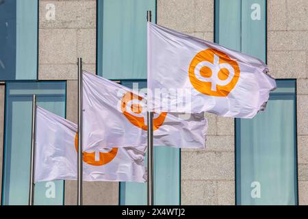 Le bandiere con il logo dell'OP Financial Group sventolano nel vento davanti alla sede centrale dell'azienda a Gebhardinaukio 1 nel quartiere Vallila di Helsinki, Finlandia. Foto Stock