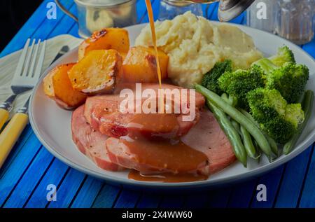 Cena con arrosto al Gammon con salsa gravy. Foto Stock