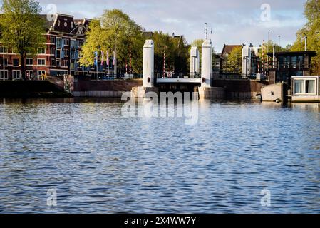 Ponte di sollevamento Kikkerbilssluis e magazzino delle Indie occidentali ad Amsterdam, Paesi Bassi. Foto Stock