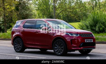 Milton Keynes, Regno Unito - 5 maggio 2024: 2020 auto Land Rover Discovery Sport rossa che guida su una strada britannica Foto Stock