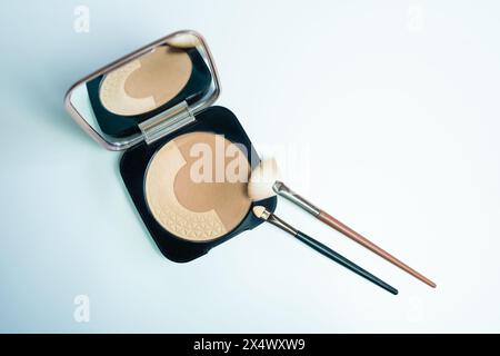 Vista dall'alto di un piccolo kit di trucco con polveri bronzanti e due diversi tipi di spazzole da applicare sul viso Foto Stock