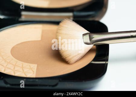 Un piccolo kit di trucco con polveri bronzanti e una spazzola per applicarle sul viso Foto Stock