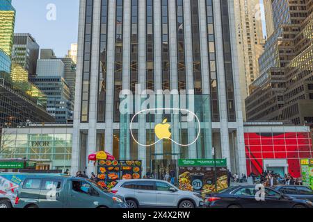 Vista dell'Apple Store sulla Fifth Avenue a New York, con iconica facciata in vetro con grande logo Apple, circondato dal traffico cittadino e vicino Foto Stock