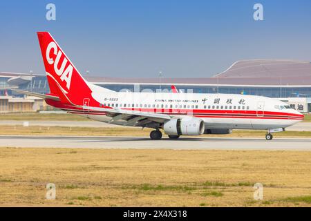 La Cina ha Unito aerei di linea Boeing 737 con Yunnan Peacock (arancione) all'aeroporto di Shanghai in Cina nell'aprile 2024 Foto Stock