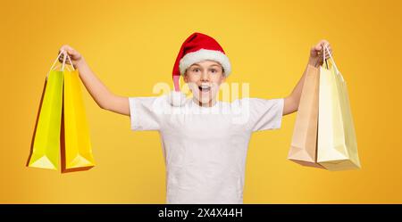 Adolescente emozionale che si diverte a fare shopping con i sacchetti di carta Foto Stock