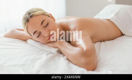 Bella donna che si stende sopra un letto Foto Stock