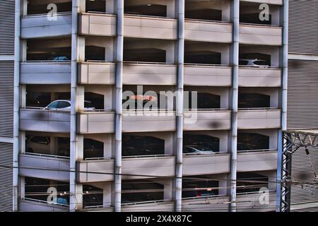 Un garage a più livelli pieno di auto, che mostra una moderna infrastruttura urbana per il rimessaggio dei veicoli. Foto Stock