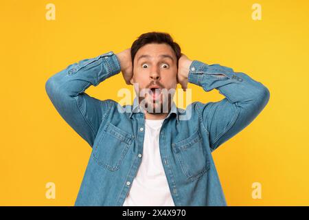 Uomo con un'espressione sorpresa che tocca la testa Foto Stock