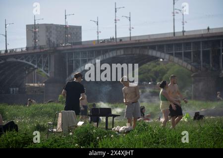 Varsavia, Polonia. 5 maggio 2024. Il 5 maggio 2024, i giovani vengono visti fare il barbequequequequequequequeing e rilassarsi lungo le rive del fiume Vistola, un'area designata natura 2000 a Varsavia, in Polonia. La Polonia e l'Europa orientale hanno visto un clima eccezionalmente caldo all'inizio della stagione primaverile con temperature che salgono a quasi 30 gradi Celsius in diverse parti della regione. (Foto di Jaap Arriens/Sipa USA) credito: SIPA USA/Alamy Live News Foto Stock