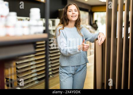 Cliente femmina che tiene campioni di pannelli di legno nel negozio di ferramenta Foto Stock