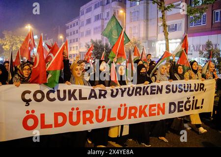 Istanbul, Turchia. 5 maggio 2024. I manifestanti tengono uno striscione che dice "mentre i bambini dormono, prevale il silenzio, non mentre vengono uccisi”. durante la marcia. Centinaia di persone hanno marciato a Istanbul la sera del 5 maggio per esprimere la loro solidarietà al popolo palestinese. I manifestanti hanno condannato gli attacchi israeliani e hanno chiesto un cessate il fuoco immediato e l'accesso agli aiuti umanitari. La marcia ha fatto eco alle richieste globali di pace nella regione. (Foto di Ibrahim oner/SOPA Images/Sipa USA) credito: SIPA USA/Alamy Live News Foto Stock