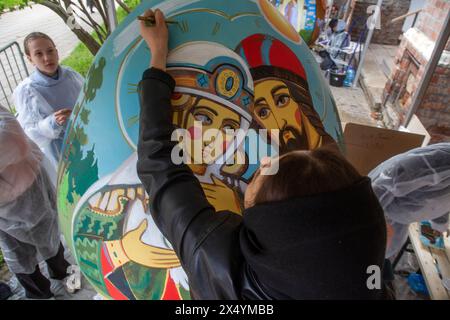 Mosca, Russia. 5 maggio 2024. Giovani artisti dipingono uova di Pasqua giganti durante la celebrazione della Pasqua ortodossa al monastero Vysokopetrovsky di Mosca, Russia Foto Stock
