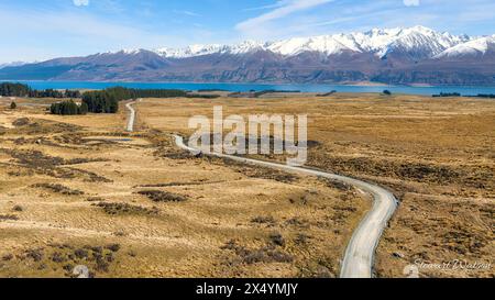 Strada rurale di ghiaia, (Braemar Road) che attraversa la campagna interna tra il lago Tekapo e il lago Pukaki Foto Stock