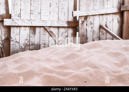 Recinzione con tavole di legno e pila di sabbia sulla spiaggia del Danubio, attenzione selettiva Foto Stock