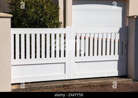 porta tavole classiche in plastica pvc bianco cancello di casa porta della periferia casa città strada Foto Stock