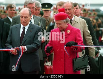 Foto del file del 06/05/1994 della regina Elisabetta II e del presidente francese Francois Mitterrand che tagliava il nastro per aprire ufficialmente il tunnel della Manica a Coquelles, in Francia. Un esperto di viaggi ferroviari internazionali ha chiesto a Eurostar di affrontare una concorrenza diretta, poiché il tunnel della Manica compie 30 anni lunedì. Mark Smith, fondatore del sito web internazionale Seat61.com, ha affermato che avere una seconda compagnia che opera servizi ferroviari passeggeri verso il continente potrebbe portare a tariffe più basse e a nuove destinazioni. Data di pubblicazione: Lunedì 6 maggio 2024. Foto Stock