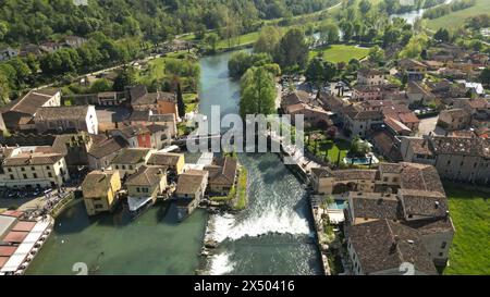 Bellissimo villaggio sulla riva del fiume vista aerea del villaggio mulino di Borghetto sul Mincio a sud del Lago di Garda, in Veneto. Drone Foto Stock