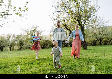 Ritratto di famiglia con la figlia e il bambino piccolo, il bambino, camminando all'aperto nella natura primaverile. Foto Stock