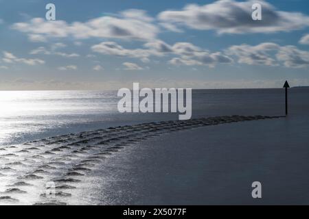 Concrete Groynes, conosciuta localmente come Cobbolds Point, si snoda nel Mare del Nord dalla spiaggia di Felixstowe, Suffolk, Inghilterra, Regno Unito. Febbraio 2024 Foto Stock