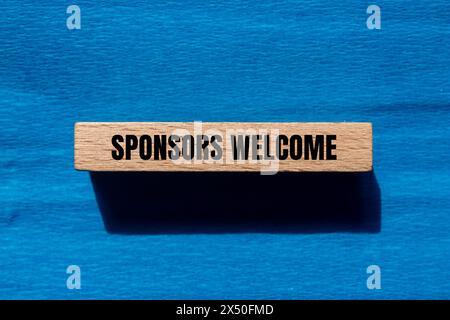 Gli sponsor accolgono le parole scritte su un blocco di legno con sfondo blu. Simbolo commerciale concettuale. Copia spazio. Foto Stock